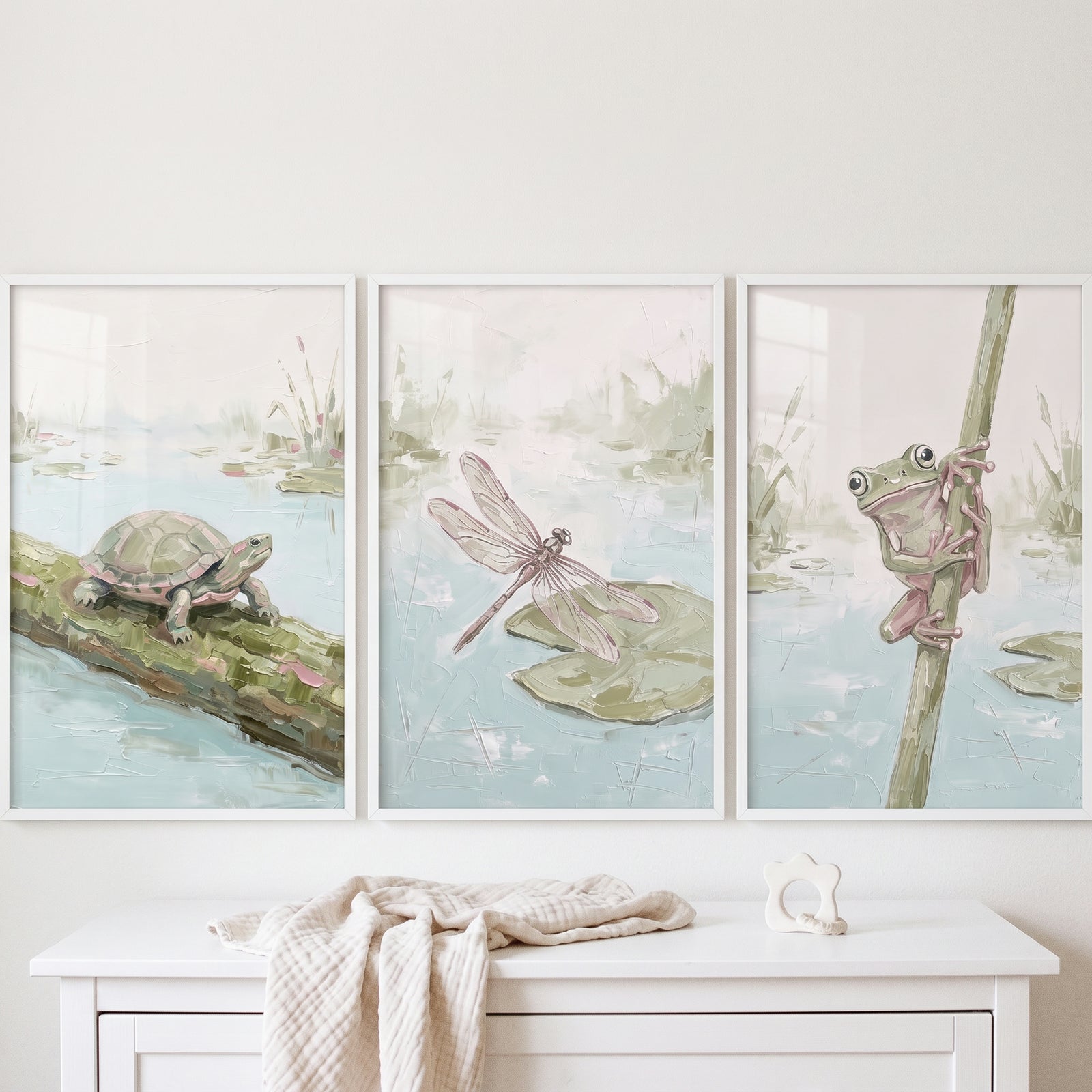 Soft sage pond animals wall art set of 3 featuring a turtle, dragonfly, and frog in white frames above a dresser.