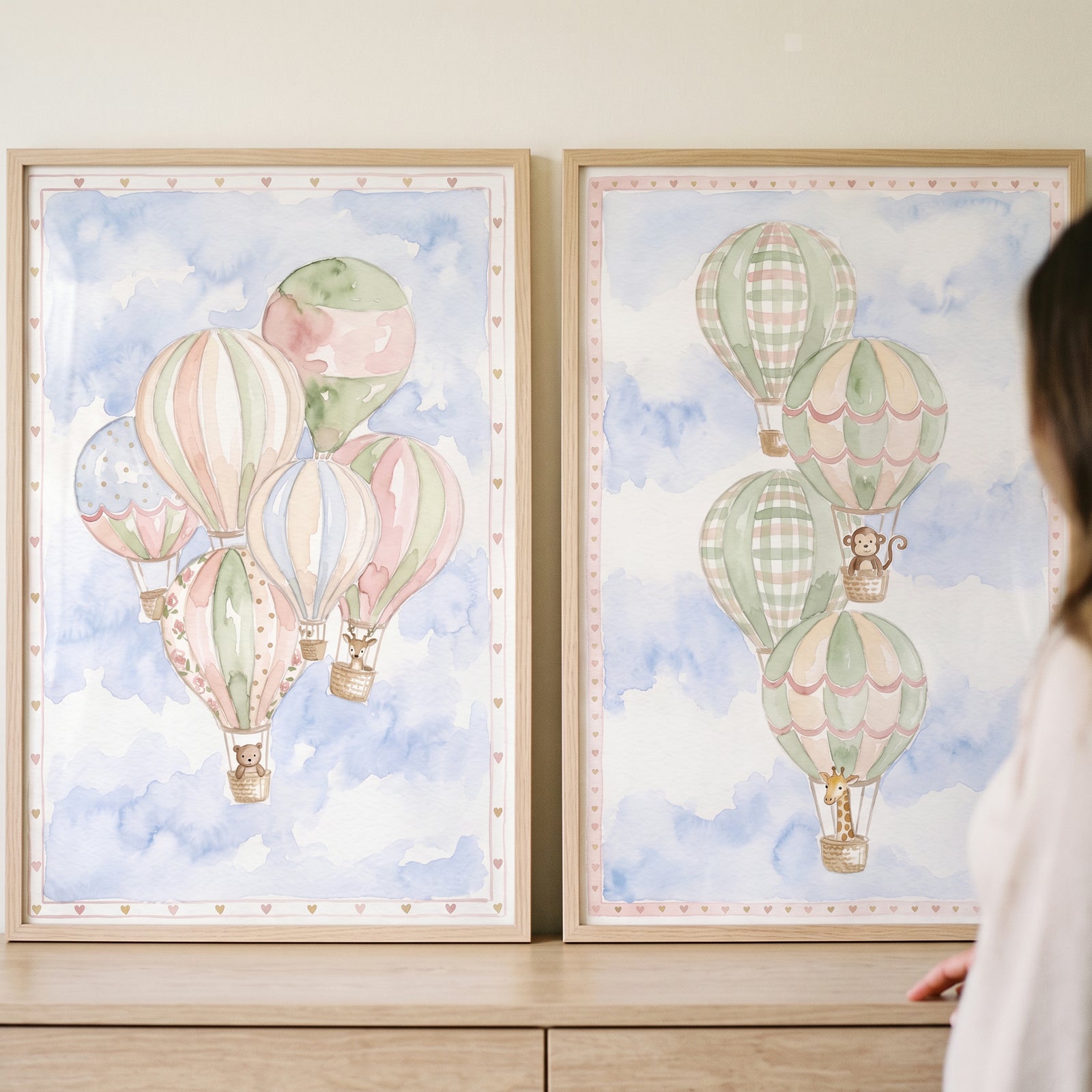 Soft sky hot air balloon artwork set of 2 with cute animals in baskets floating among blue watercolor clouds.