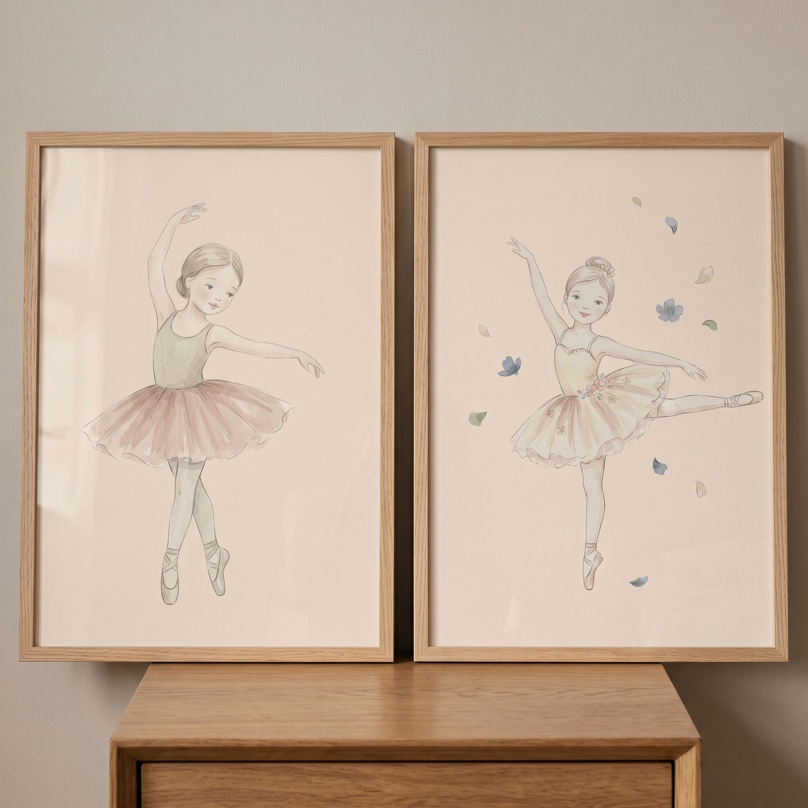 Soft tan ballerina wall art set of 2 in wood frames. Delicate illustrations of young dancers resting on a dresser.