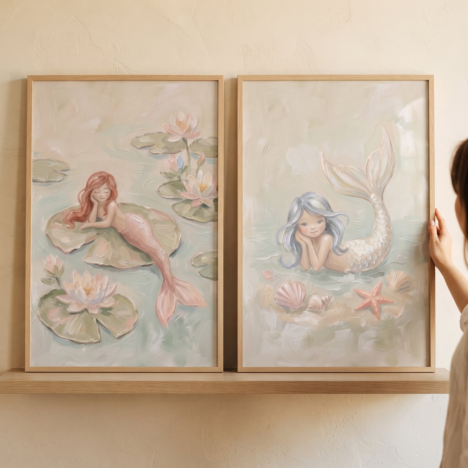 Soft textured dreamy mermaid wall art set of 2 in wood frames, featuring whimsical mermaids, lily pads, and seashells.