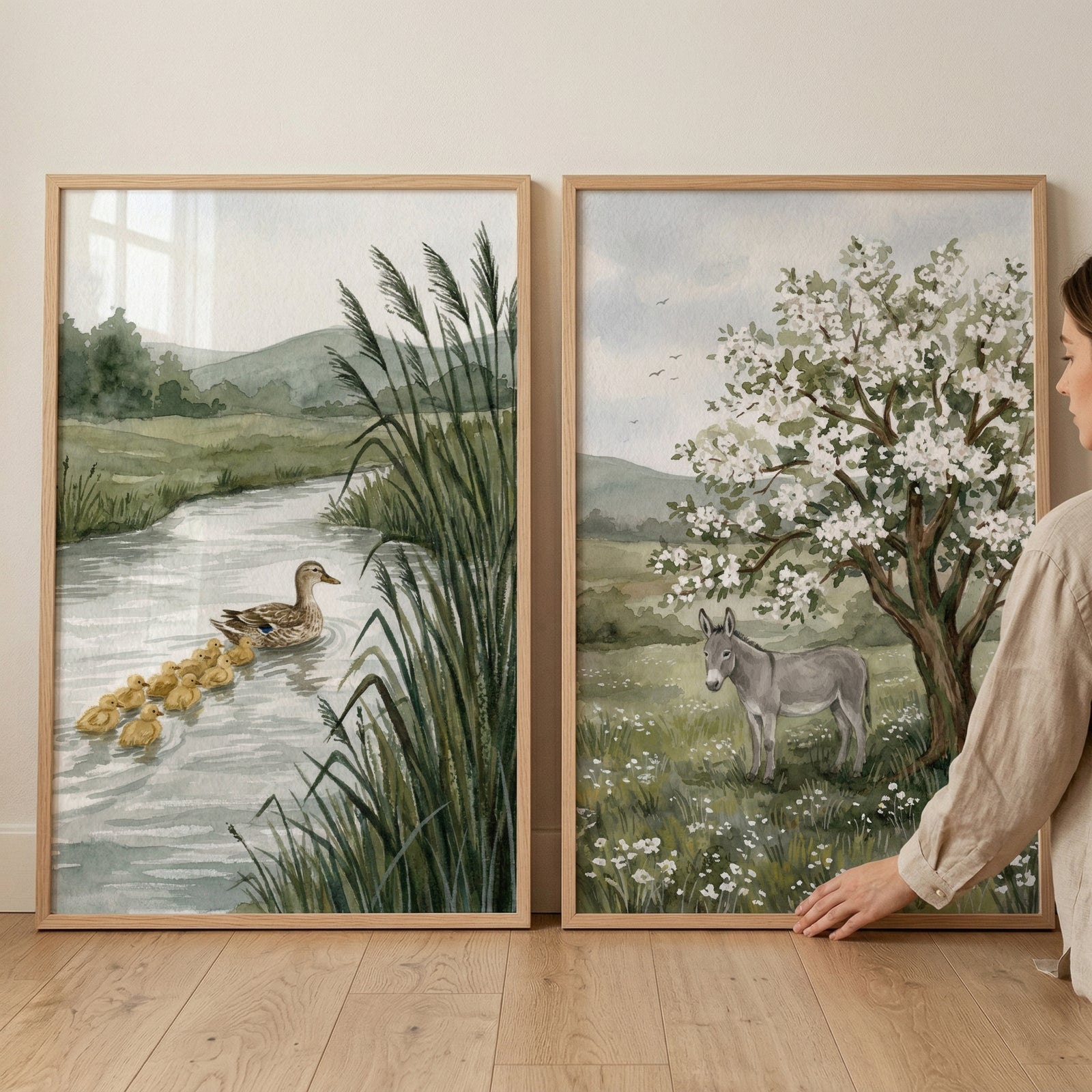 Soft watercolor countryside animal wall art set of 2 featuring ducks in a river and a donkey by a blossoming tree.