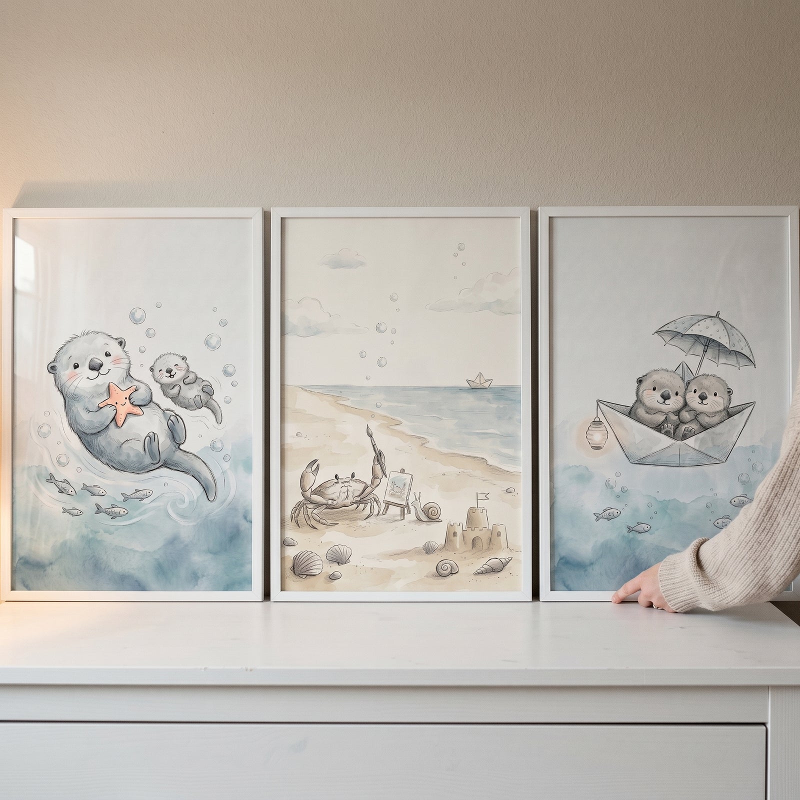 Soft watercolor sea animal wall art set of 3 featuring cute otters and a beach crab in white frames.