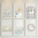 Six framed watercolor illustrations arranged in a grid feature white ducks in soft nature scenes including splashing in water standing among flowers drinking from a stream and resting in a floral wreath. The pastel colors and gentle details create a cohesive calm nursery wall display with a sweet countryside feel.