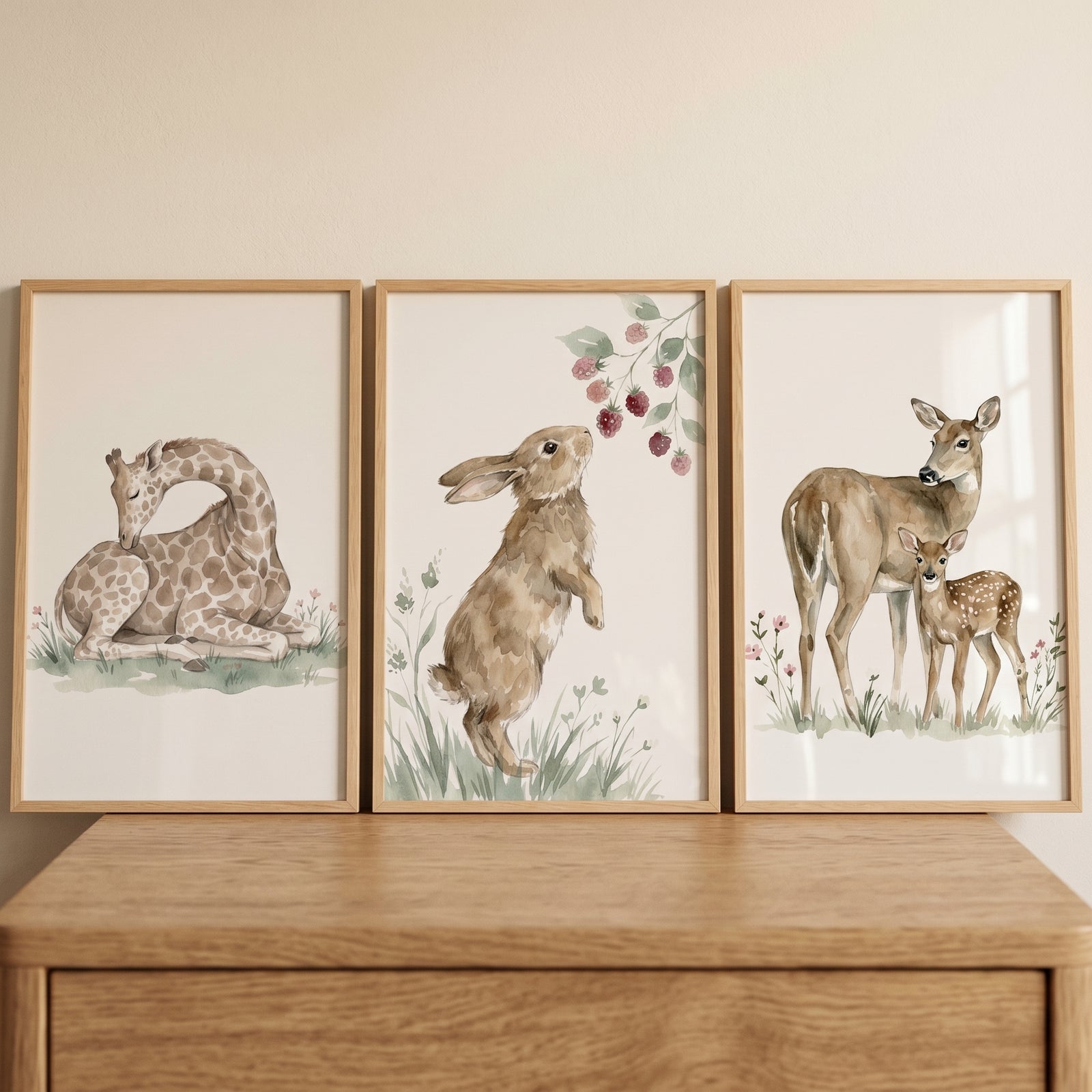 Soft woodland animal wall art set of 3 featuring a giraffe, a rabbit reaching for berries, and a doe with its fawn.