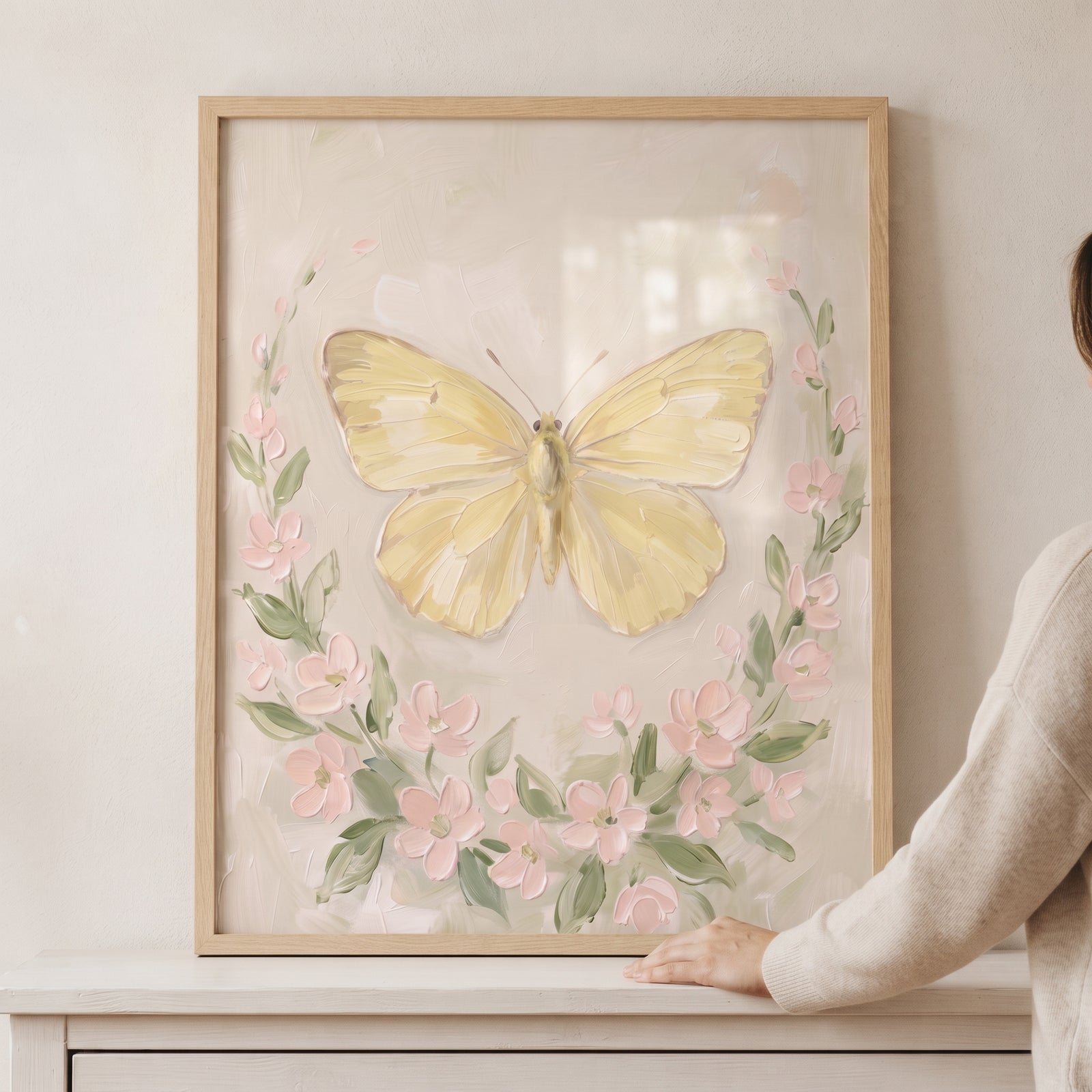 Soft yellow textured butterfly wall art with pink blossoms and green leaves in a natural wood frame.