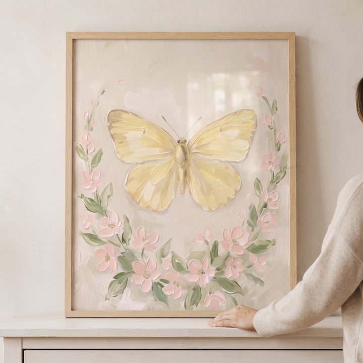 Soft yellow textured butterfly wall art with pink blossoms and green leaves in a natural wood frame.