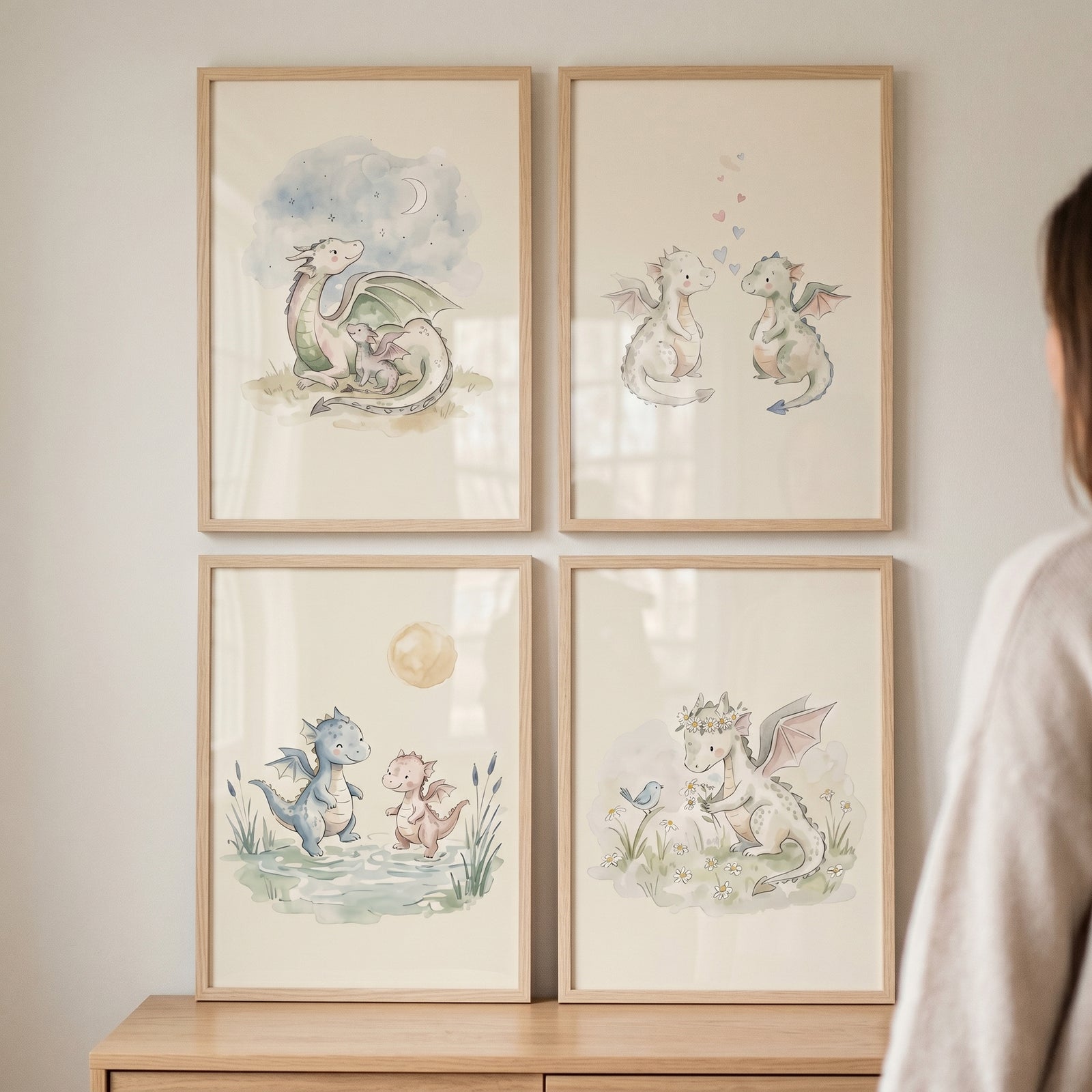Sophisticated pastel baby dragon wall art set of 4 in light wood frames hangs on a wall above a wooden dresser.