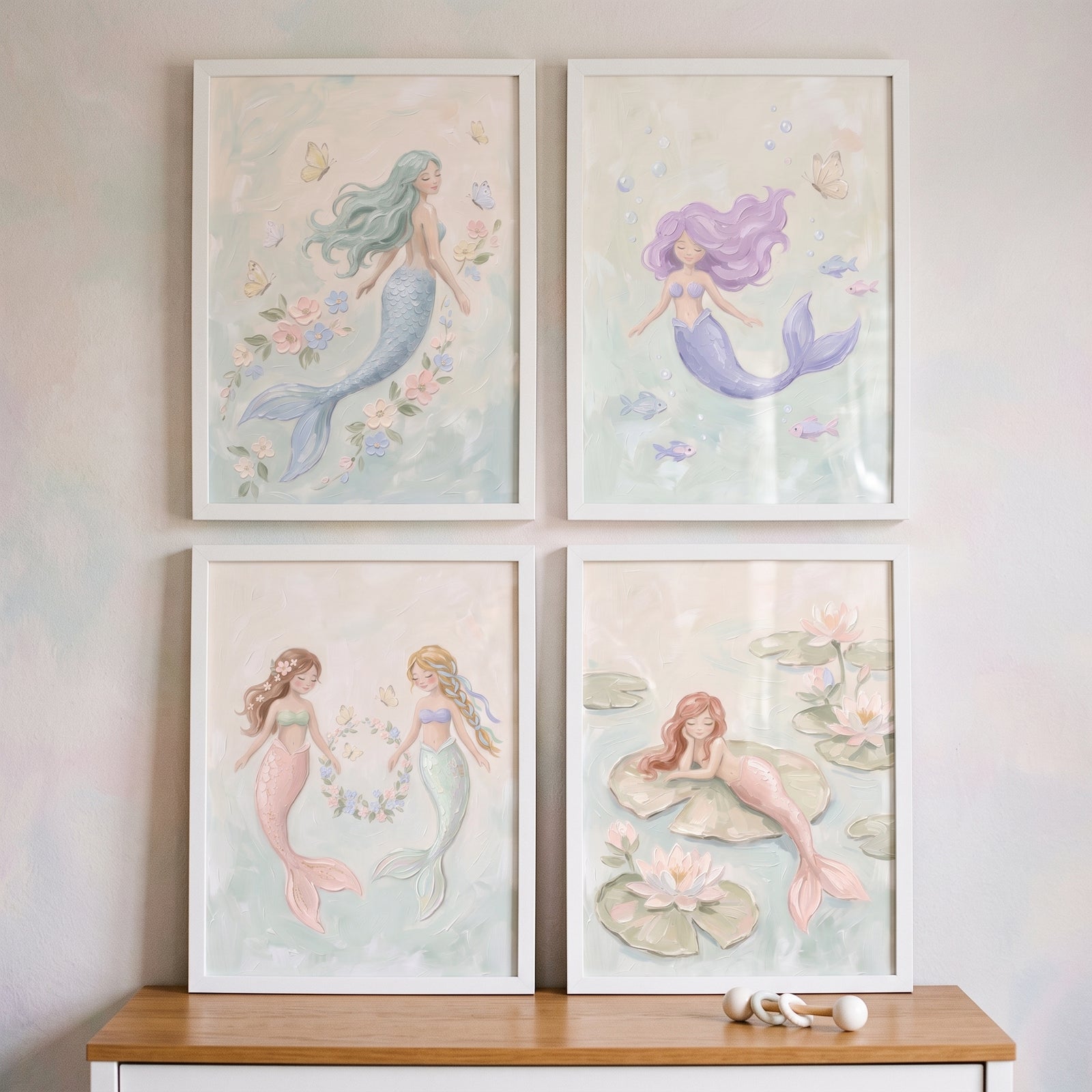 Sophisticated pastel underwater mermaid wall art set of 4 in white frames displayed on a wall above a wooden table.