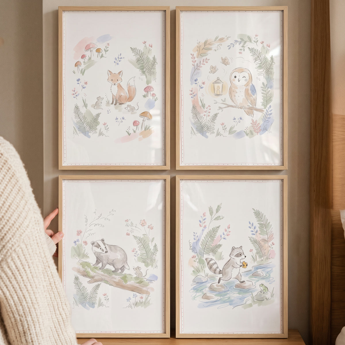 Four wood frames display a sophisticated watercolor woodland animals wall art set of 4 featuring a fox, owl, badger, and.
