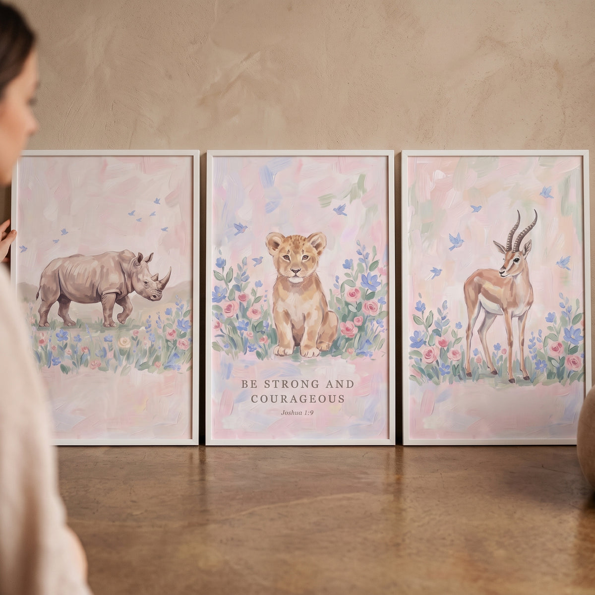 Sophisticated wildflower savanna animals wall art set of 3 with a rhino, lion cub, and gazelle in pastel floral scenes.