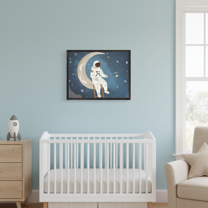 Modern nursery with light blue walls. A white crib, a wooden dresser with a rocket, and a beige armchair are visible. A framed illustration of a dark-skinned astronaut in a white suit, sitting on a crescent moon, holding a star, hangs centered above the crib against a starry blue sky.