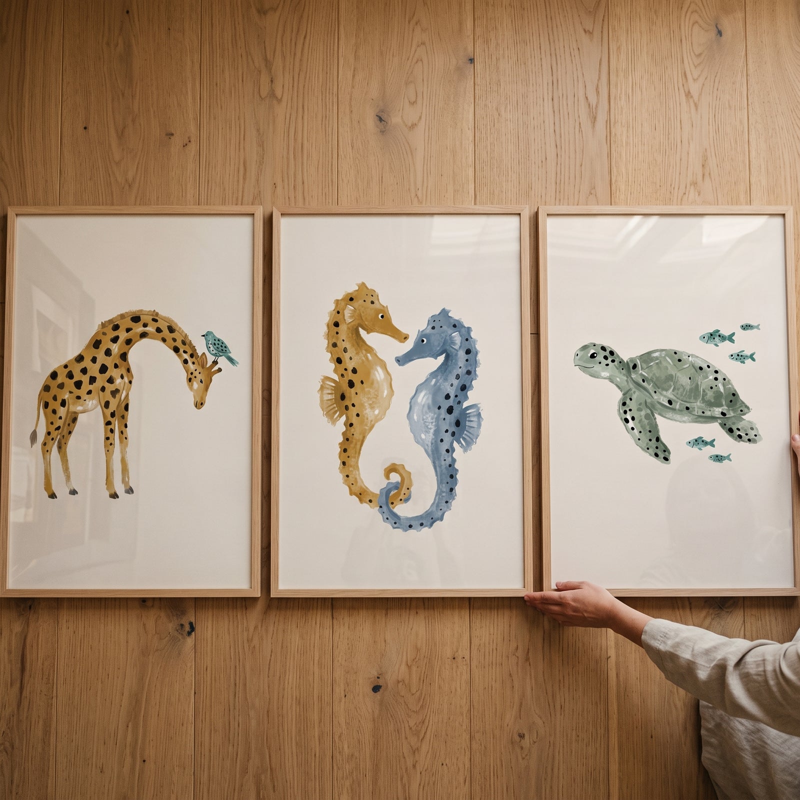 Speckled earthy watercolor animal wall art set of 3 featuring a giraffe, seahorses, and a turtle in wooden frames.
