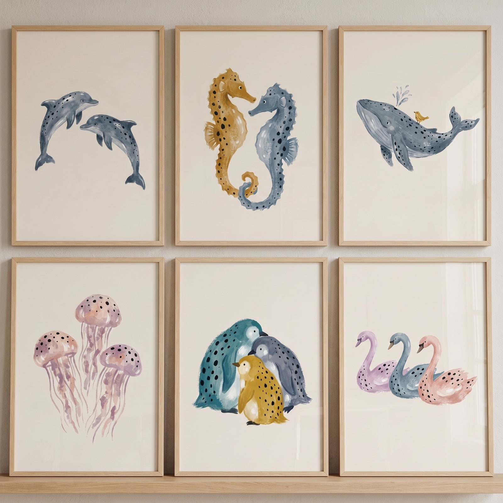Speckled watercolor aquatic animal wall art set of 6 featuring dolphins, seahorses, a whale, jellyfish, penguins, and swans.