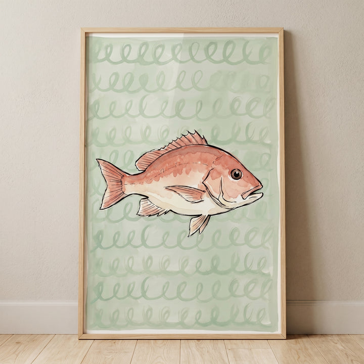 Spiral pattern sea bream fish wall art features a reddish fish on a green background in a wood frame leaning against a wall.