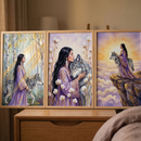 A set of three framed illustrations is displayed together on a wooden dresser. Each piece features a woman with long dark hair and a gray wolf. In the first, they walk through a sunlit forest. The central piece shows a tender moment of the woman embracing the wolf amidst tall, white flowers. The third illustration depicts them on a rocky cliff, gazing at a radiant sunrise above a sea of clouds. The set has a soft, ethereal style with a palette of purple, gold, and gray.