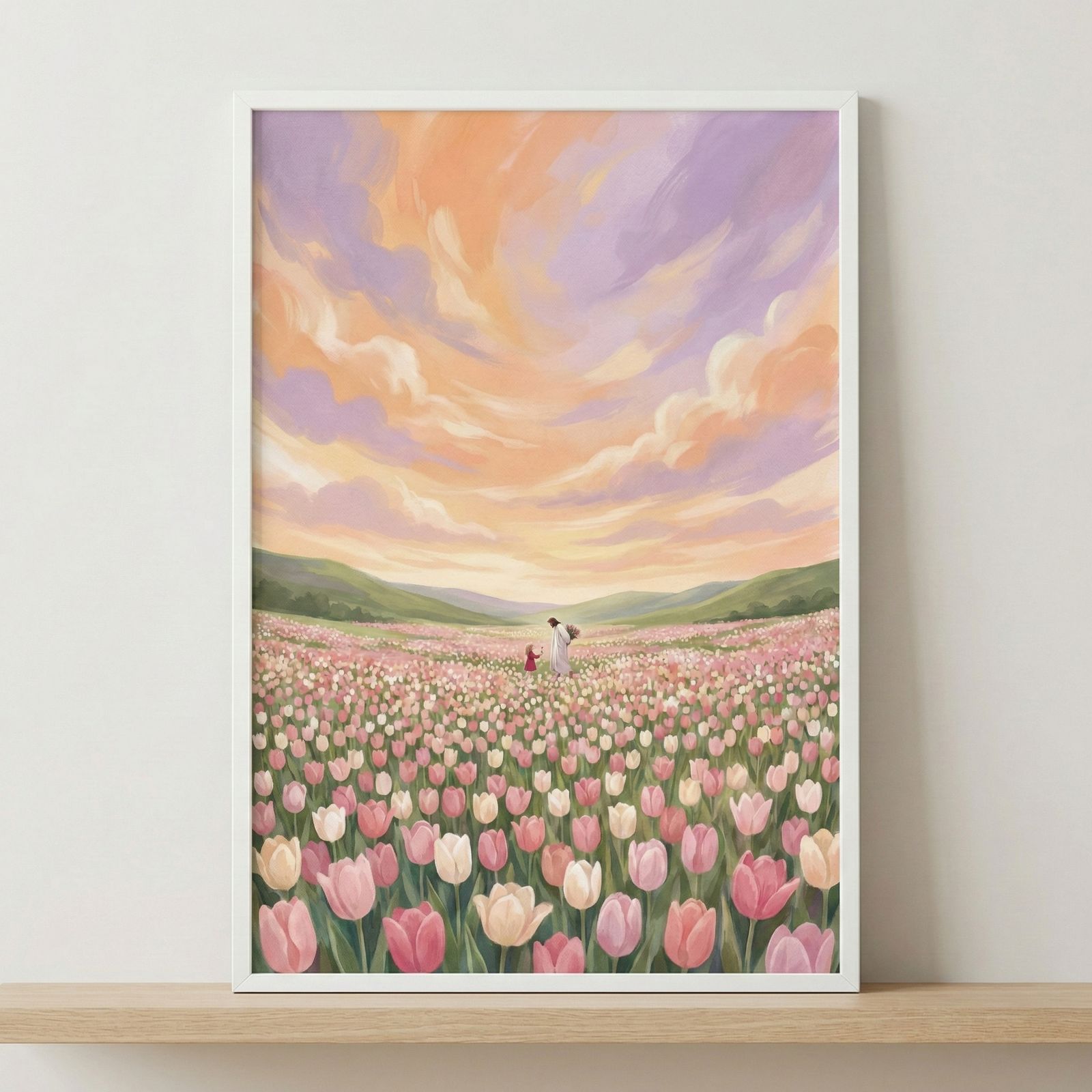 Vertical framed artwork displays a serene scene of a vast field of pink and cream tulips. In the middle distance, Jesus walks alongside a small child in a red dress. The landscape transitions into rolling green hills under an expansive, swirling sky. The clouds are rendered in soft shades of peach, orange, and lavender, evoking the glow of a sunset. This digital illustration features an expressive, soft aesthetic with visible brushwork, presented in a simple white frame on a wooden shelf.