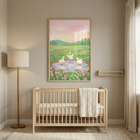 This serene nursery features a light-toned wooden crib centered against a neutral beige wall. A large framed illustration hangs above the crib, depicting a peaceful countryside scene. The artwork shows three white ducks in a small pond, surrounded by a vibrant field of pink and white tulips and green grass. In the background, rolling green hills and pine trees sit beneath a soft sunset sky with pink and yellow clouds.
