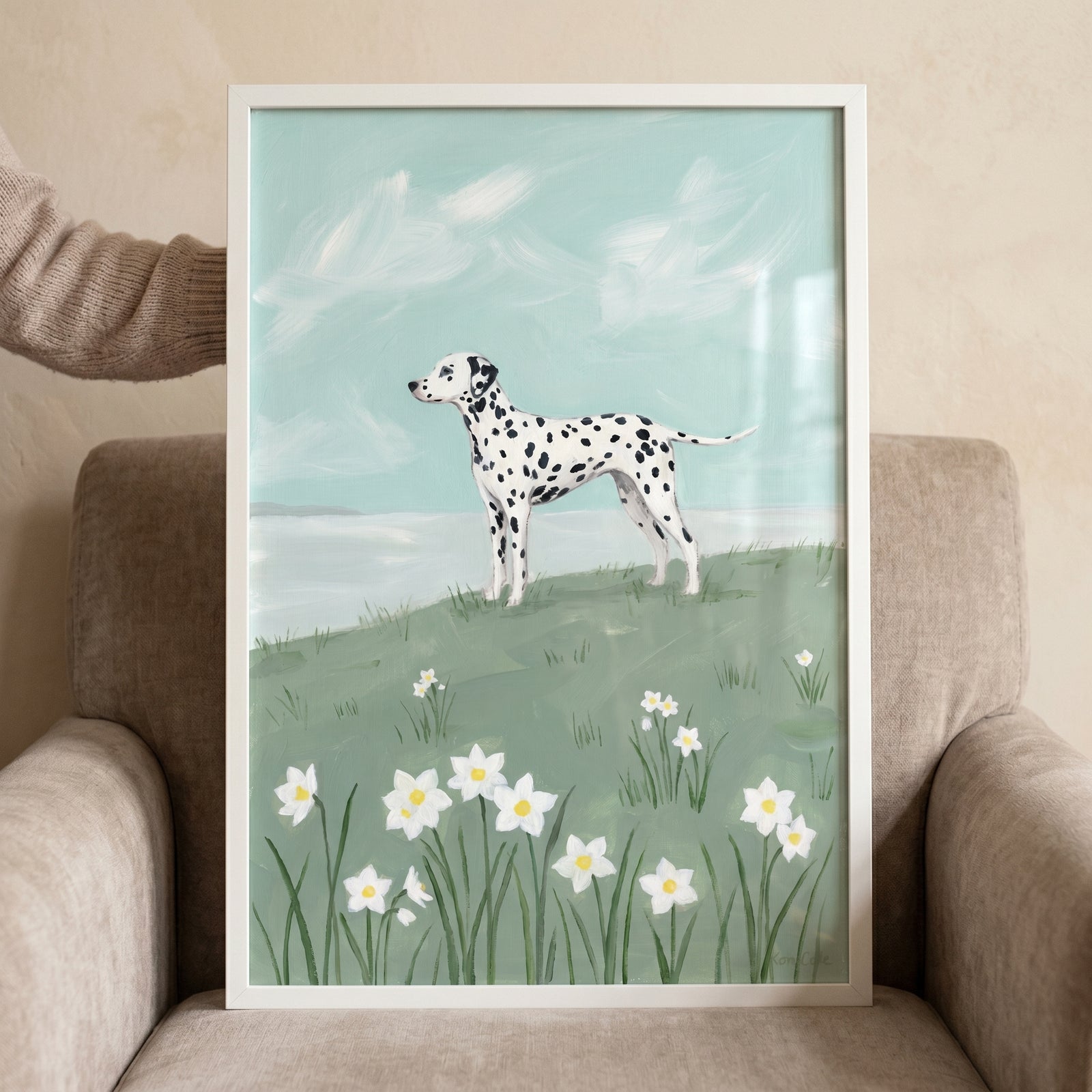 Framed spotted black white dalmatian dog wall art of a dog on a grassy hill with white flowers and a light blue sky.