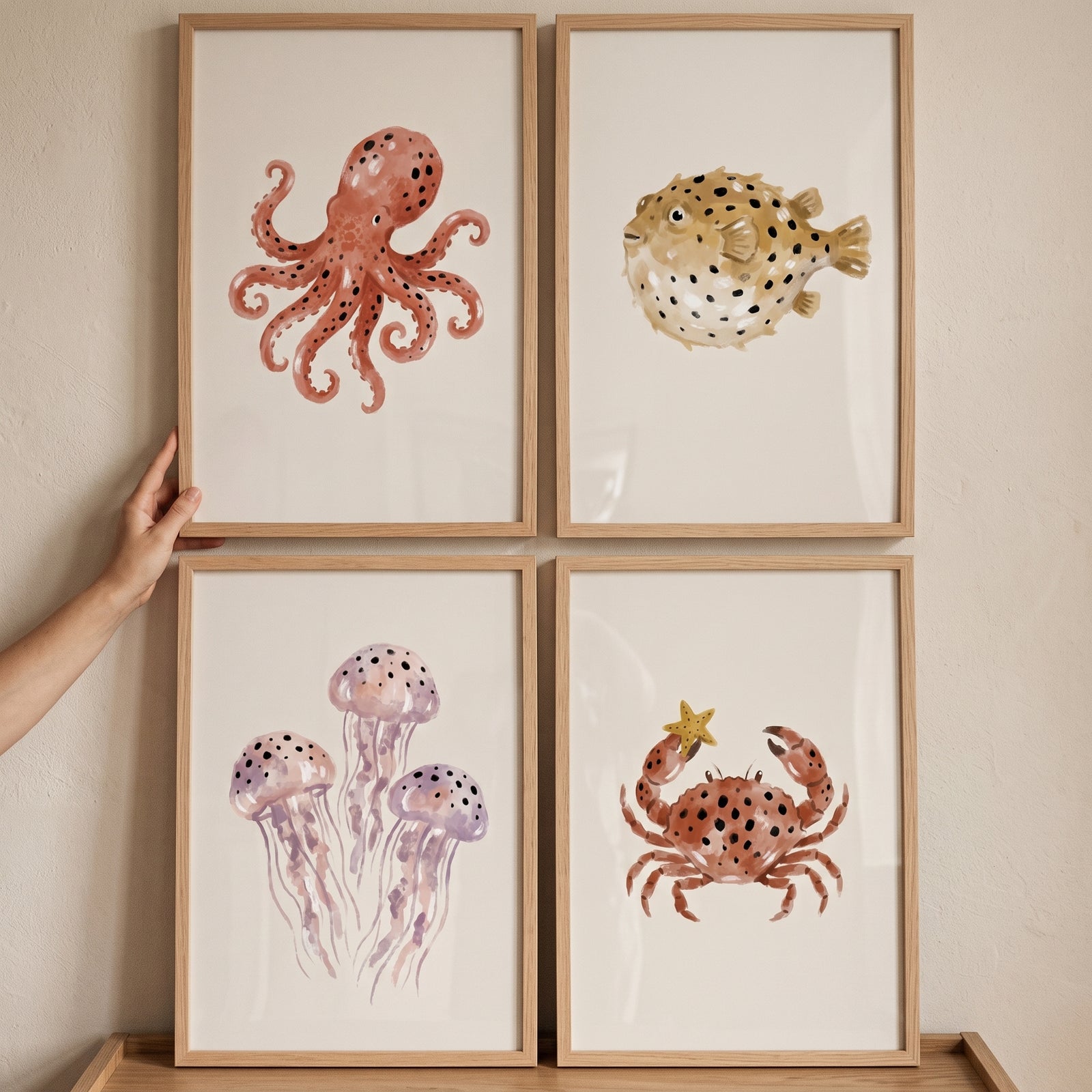 Spotted earthy sea animal wall art set of 4 featuring an octopus, pufferfish, jellyfish, and crab in light wood frames.