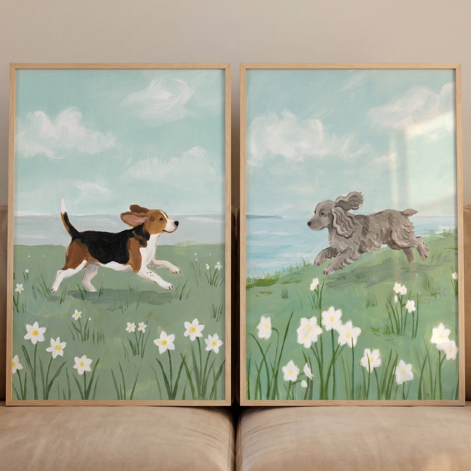 A spring meadow running dogs wall art set of 2 features two dogs bounding through white flowers under a cloudy blue sky.