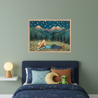 Modern nursery with a white crib, gray armchair, and white dresser. A framed painting of a person lying in a flowery field under a starry mountain sky hangs above the armchair, right of the crib.