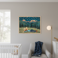 Kid's bedroom features a navy bed with constellation bedding against a green wall. Above the bed, a framed painting shows a person in a wildflower field under a starry night sky with mountains. Plush cloud, moon, and alien pillows are on the bed.