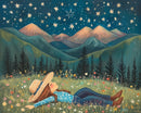 A woman in a blue floral shirt and jeans lies on a flower-filled meadow, gazing at a starry night sky. She wears a wide-brimmed hat, and the scene is framed by dark pine trees and pastel-hued mountains in the background.
