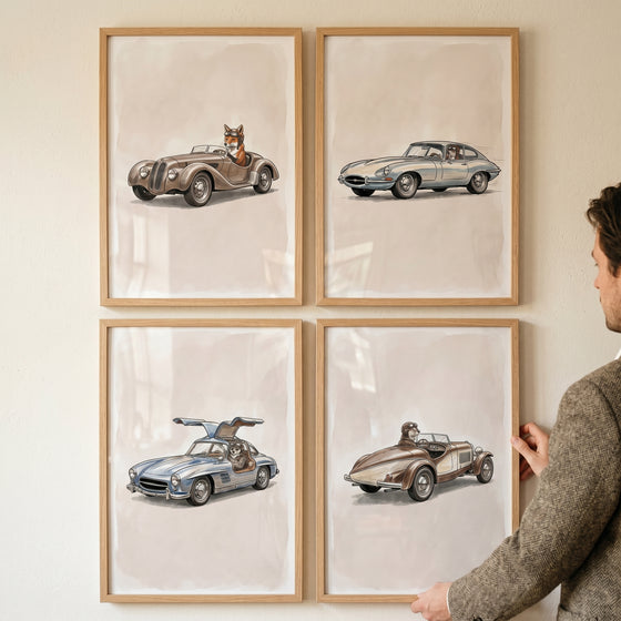A man hangs a steering wheel racing animal wall art set of 4 featuring animals driving vintage cars in light wood frames.