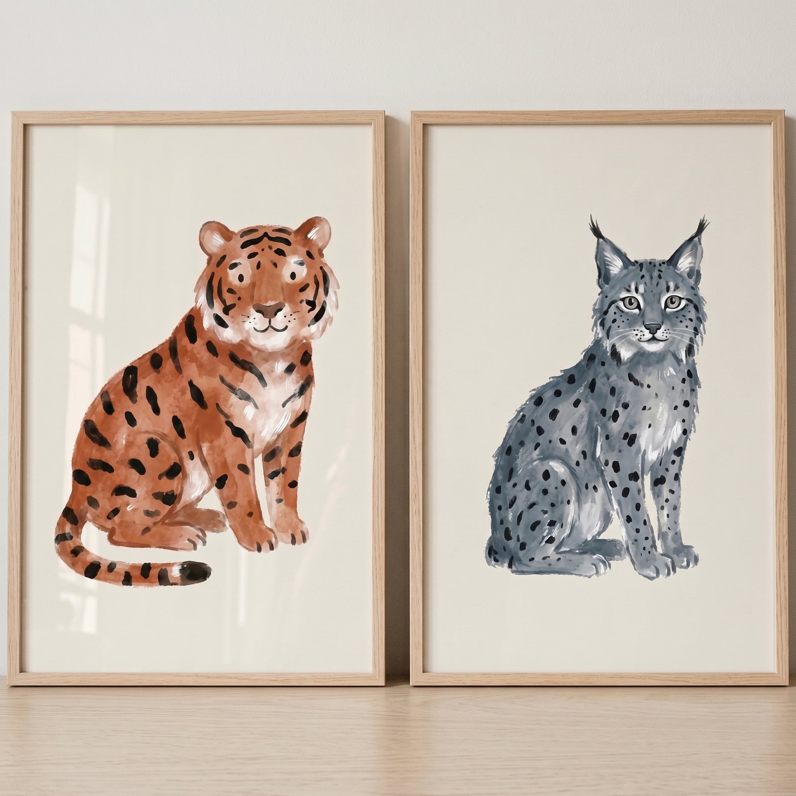 Stippled earthy wild cat wall art set of 2 featuring an orange tiger and a grey lynx in light wood frames.