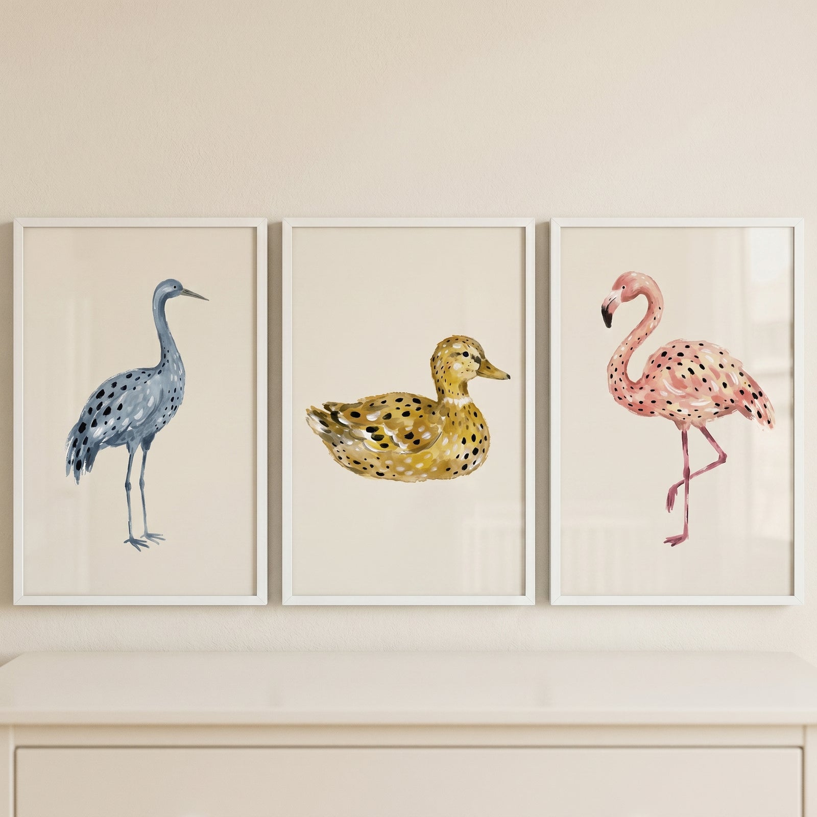 Stippled minimalist neutral birds wall art set of 3 featuring a blue crane, yellow duck, and pink flamingo over a dresser.
