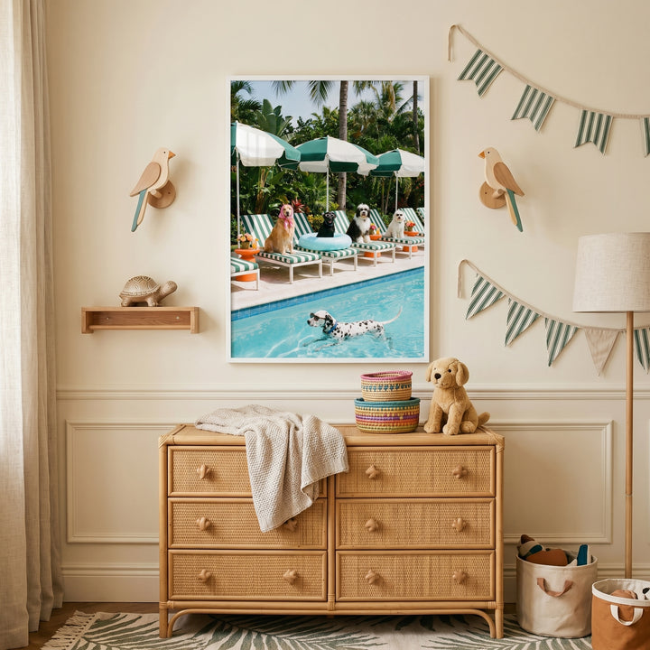 Wicker dresser in a nursery room with bird wall lamps, bunting, and summer swimming pool dogs wall art framed above.