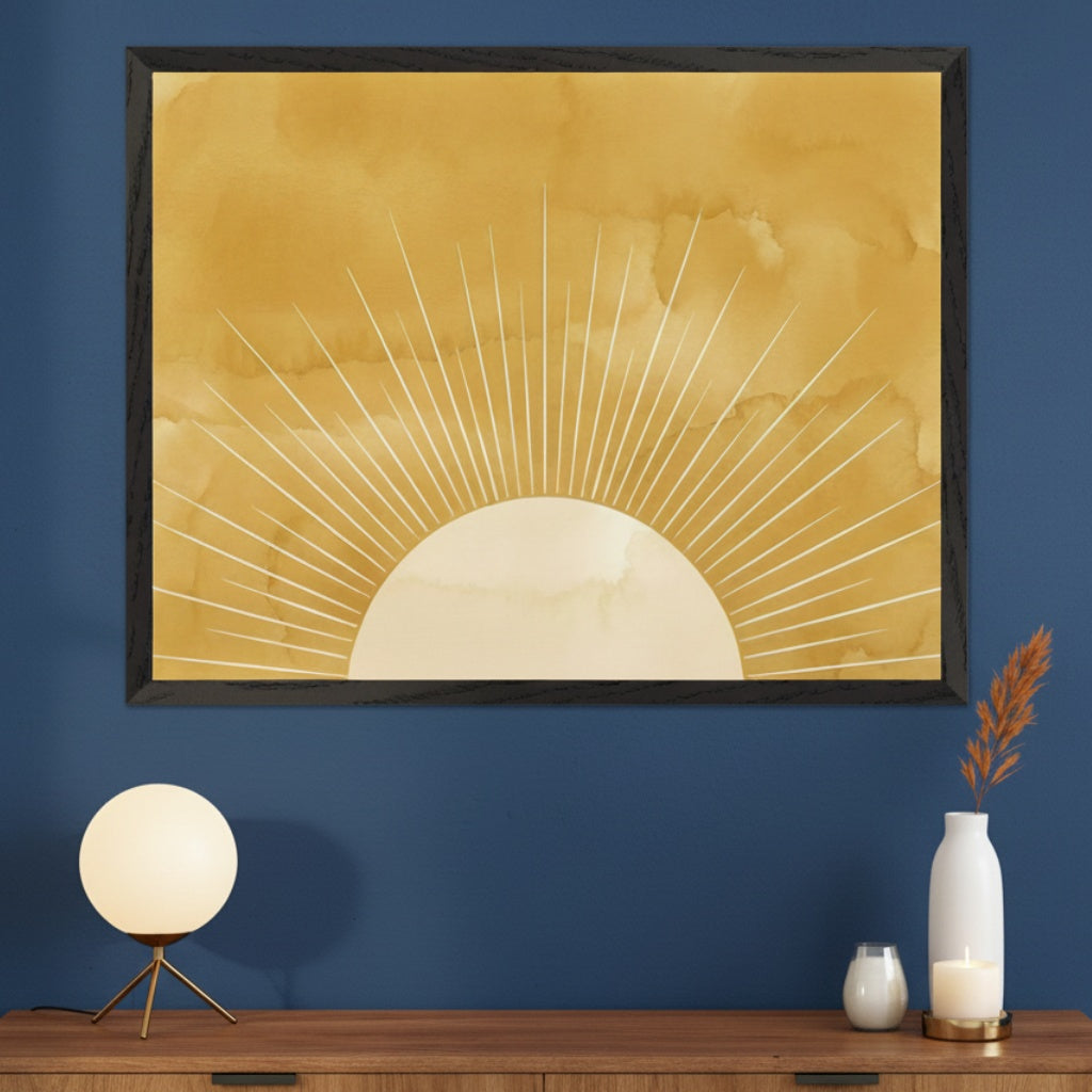 Modern room with a dark blue wall and a wooden dresser. A large framed watercolor-style print of a rising sun with white rays on a mustard yellow background hangs above the dresser. A globe lamp, vase with plumes, and candles are on the dresser.