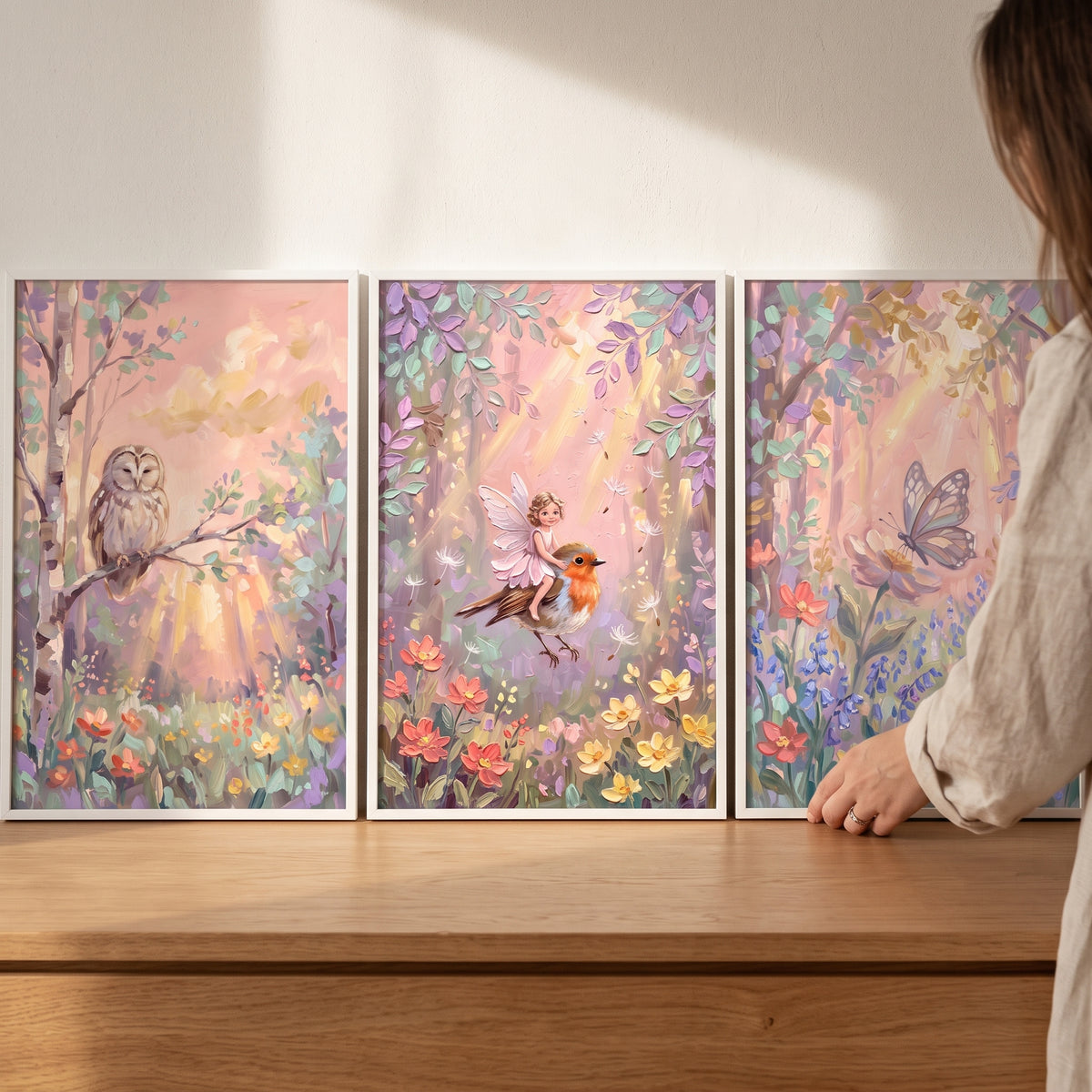 Sunlit pink enchanted forest wall art set of 3 featuring an owl, fairy riding a bird, and butterfly in floral woods.