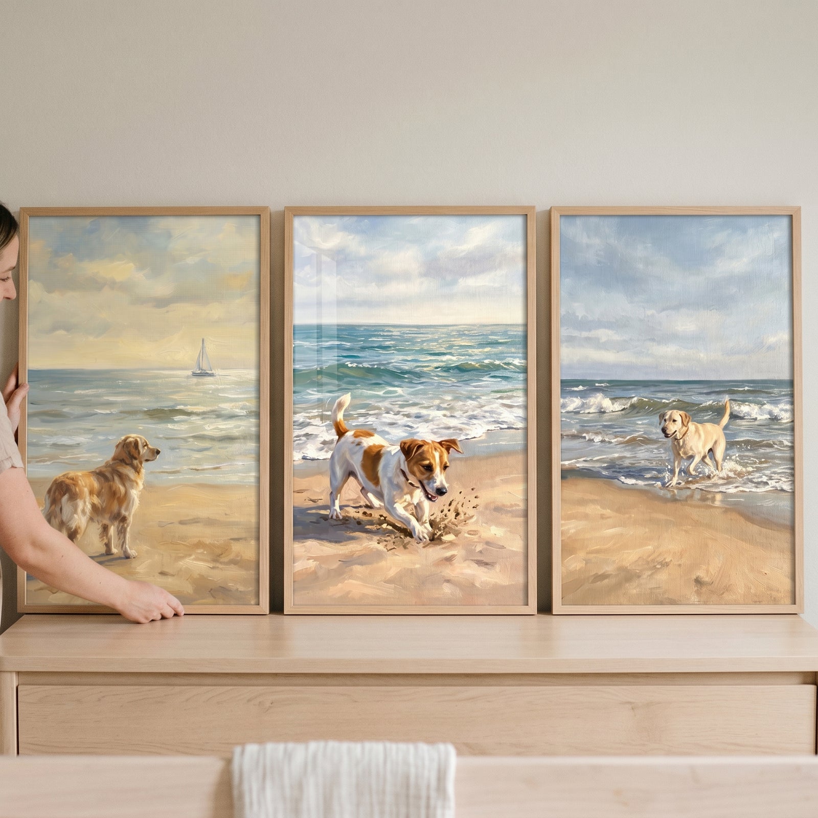 Sunny ocean shoreline dogs wall art set of 3 shows three dogs on a beach and in the water above a wooden dresser.