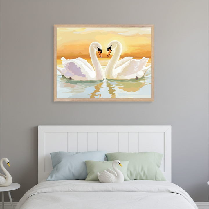 Modern bedroom with a white bed and headboard against a gray wall. Above the bed, a framed painting shows two white swans with necks forming a heart shape on water at sunset. A white swan figurine sits on a nightstand.