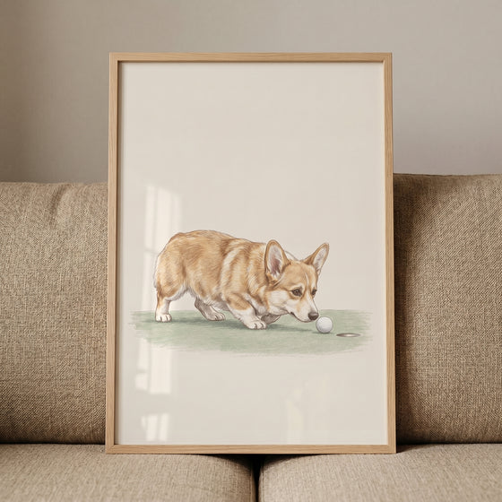 Tan white sniffing corgi dog wall art features a dog by a golf ball and hole, in a light wood frame on a beige couch.