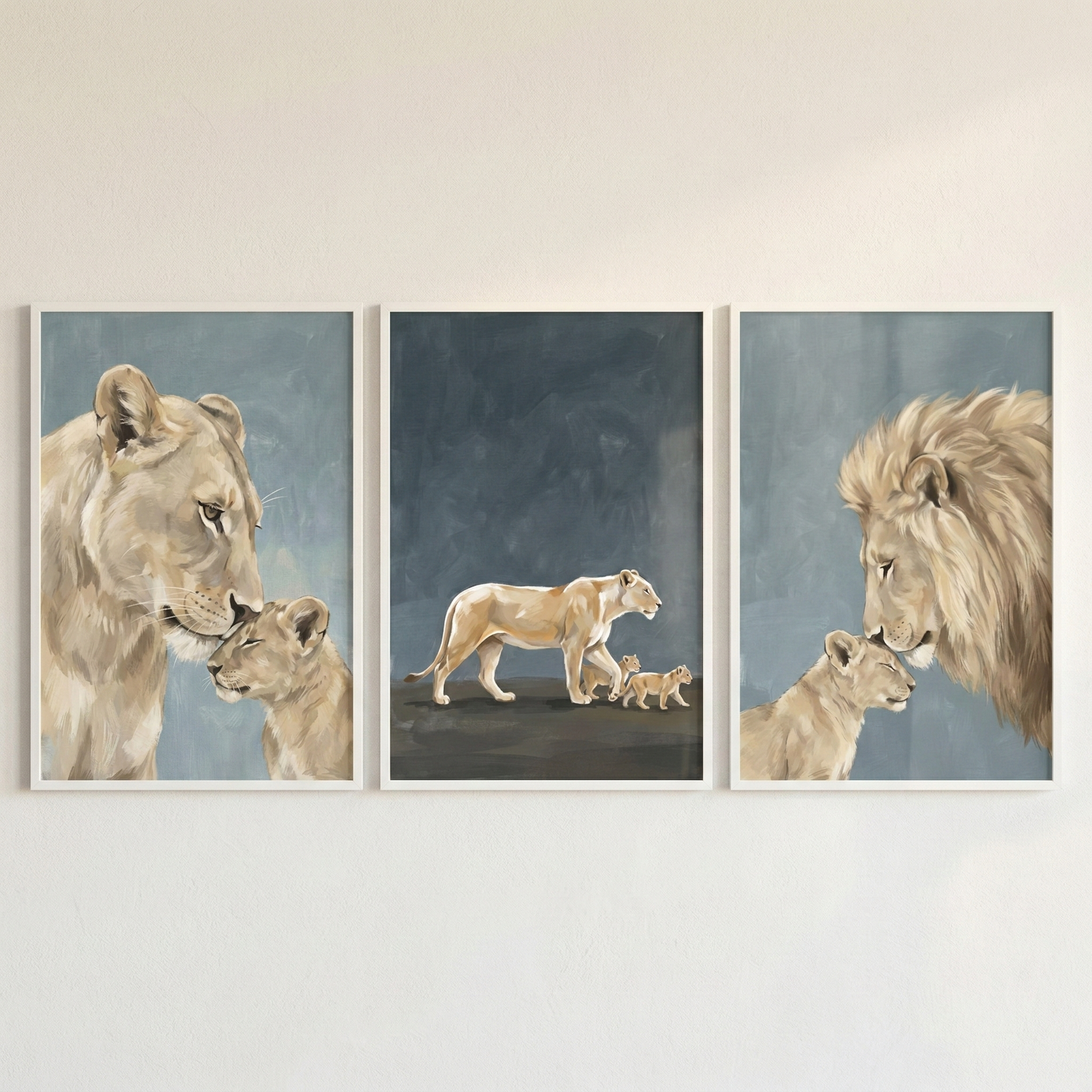 A set of three vertically-oriented framed illustrations featuring a lion family, displayed side-by-side on a neutral wall. The left frame shows a close-up profile of a lioness tenderly touching her nose to a small cub's head. The center frame depicts a lioness walking across a dark surface followed by two small cubs against a dark blue background. The right frame features a male lion with a full mane gently touching his nose to a cub's head. The art style is soft and textured in muted tones.