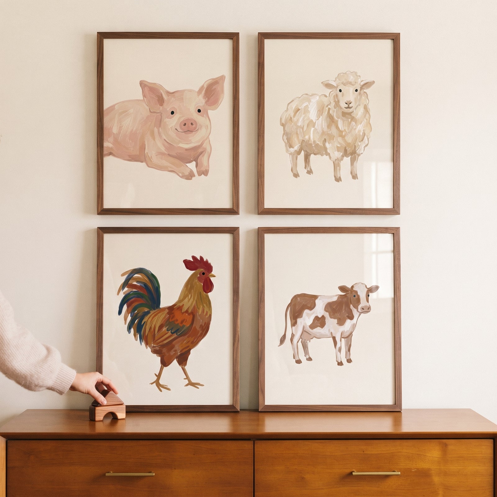 Textured beige farm animals wall art set of 4 featuring a pig, sheep, rooster, and cow hung above a wooden dresser.