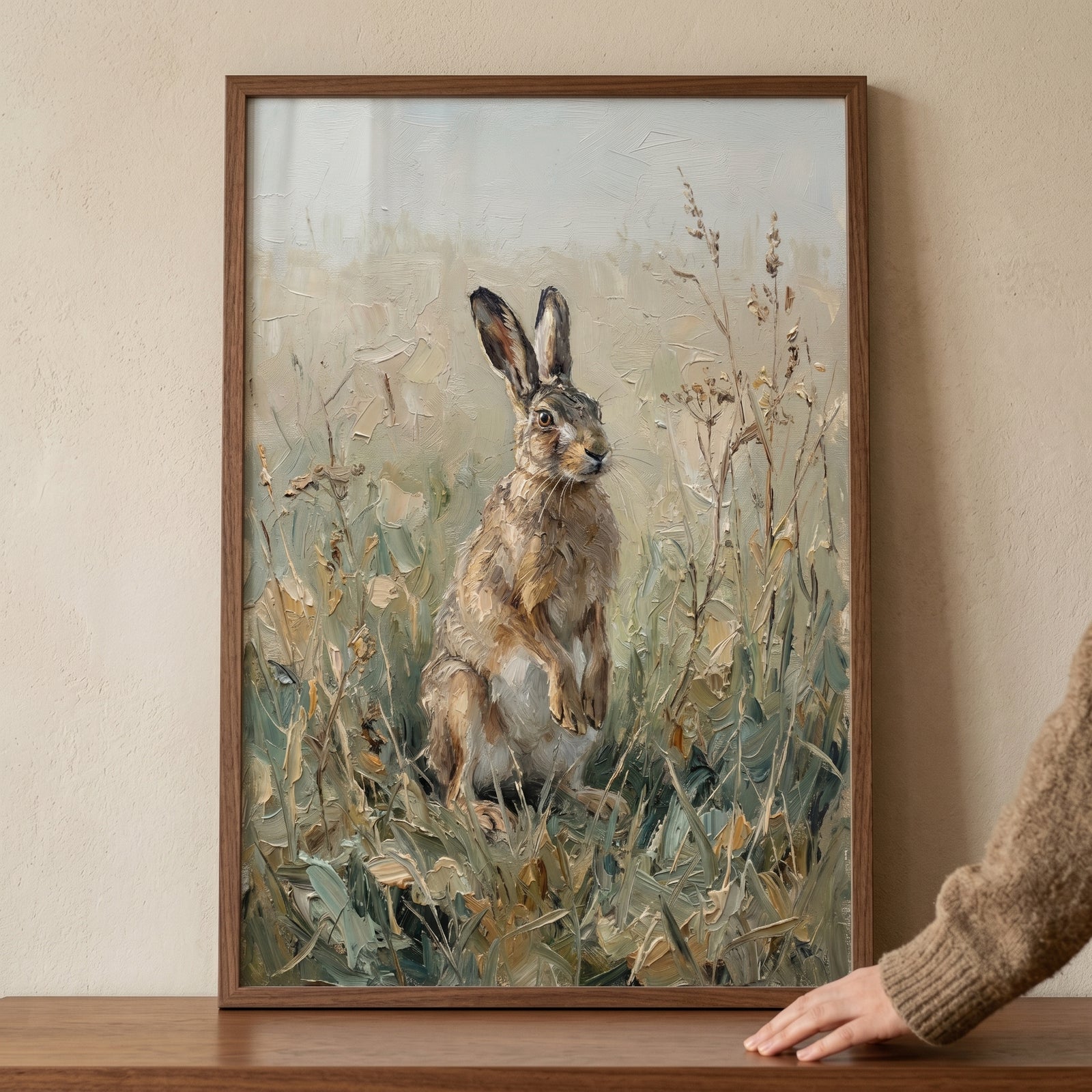 Textured neutral meadow hare wall art depicts a brown hare standing in a field of tall grass with thick, layered strokes.