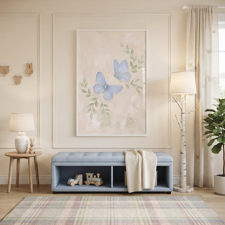 Textured pale blue butterfly artwork hangs above a blue storage bench in a soft pastel room with a plaid rug.