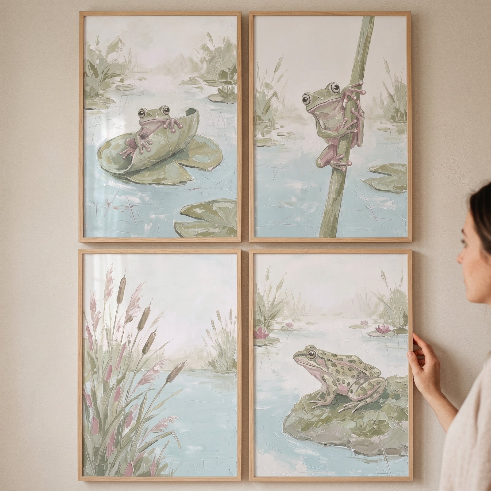 A woman hangs a textured sage green pond wall art set of 4 featuring frogs and reeds in light wood frames.
