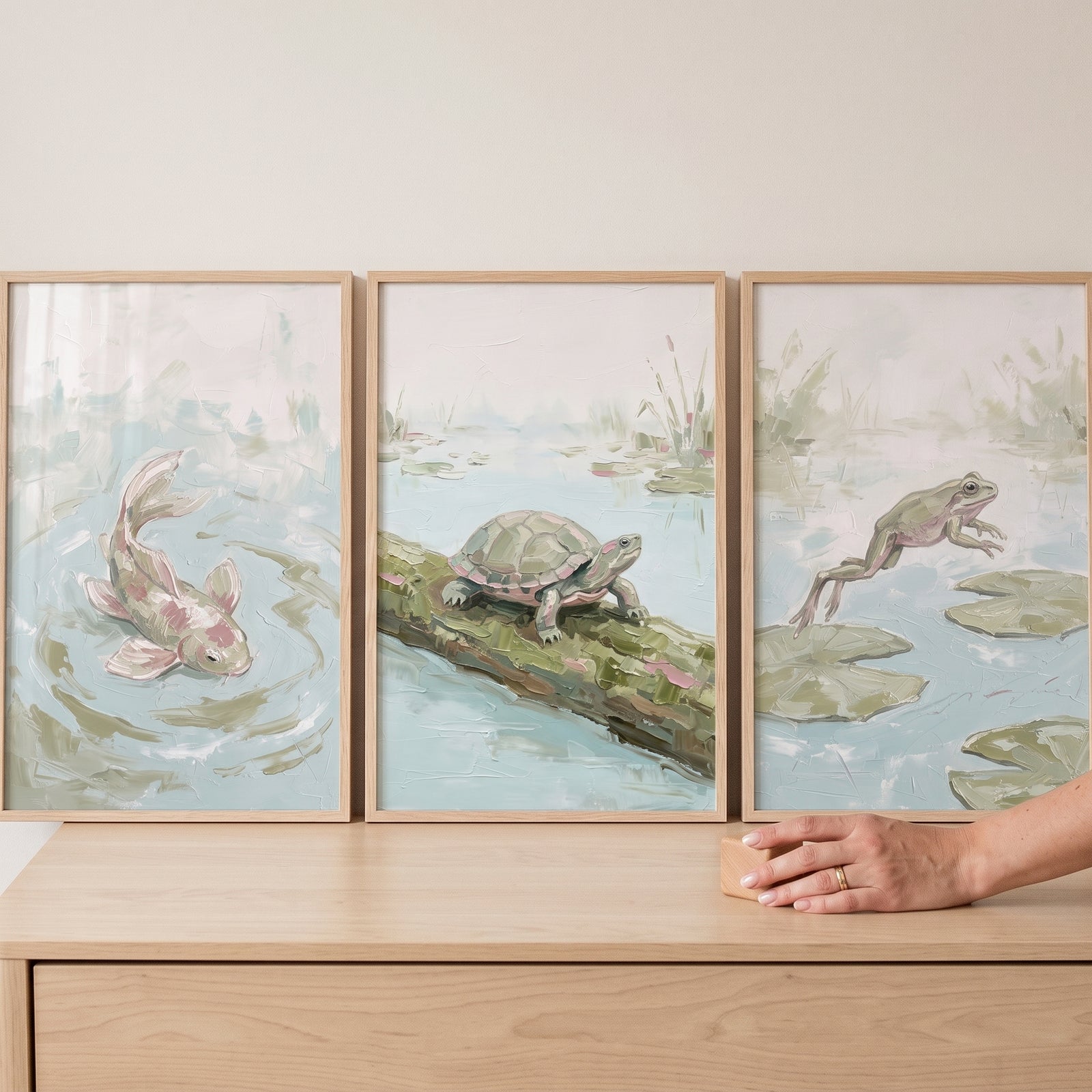 Textured sage wetland animals wall art set of 3 featuring a fish, turtle, and frog displayed on a wooden dresser.
