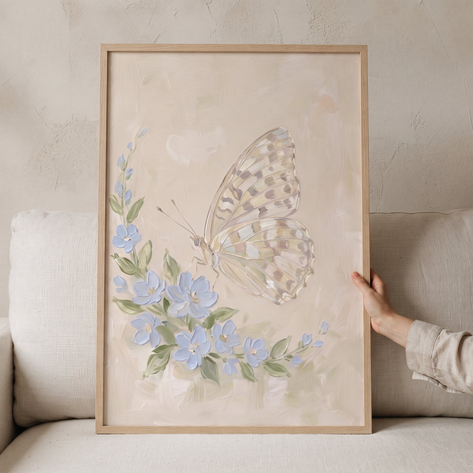 Thick impasto floral butterfly wall art in a wooden frame with blue flowers and a pale butterfly on a neutral background.