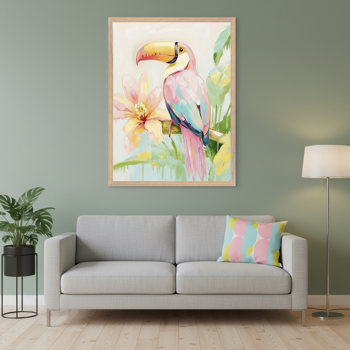 Modern living room with a gray sofa. A framed painting of a pastel pink and blue toucan with a yellow beak, beside a large pink flower, hangs centered above the sofa. A potted plant, floor lamp, and geometric pillow are also visible.