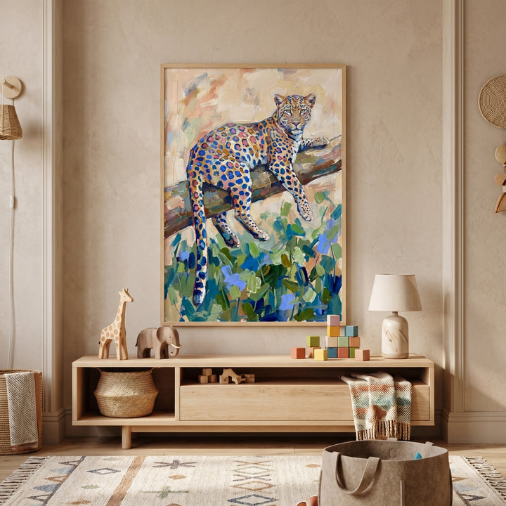 Tree branch resting leopard artwork hangs above a wooden sideboard with toys and a lamp in a neutral-toned nursery.