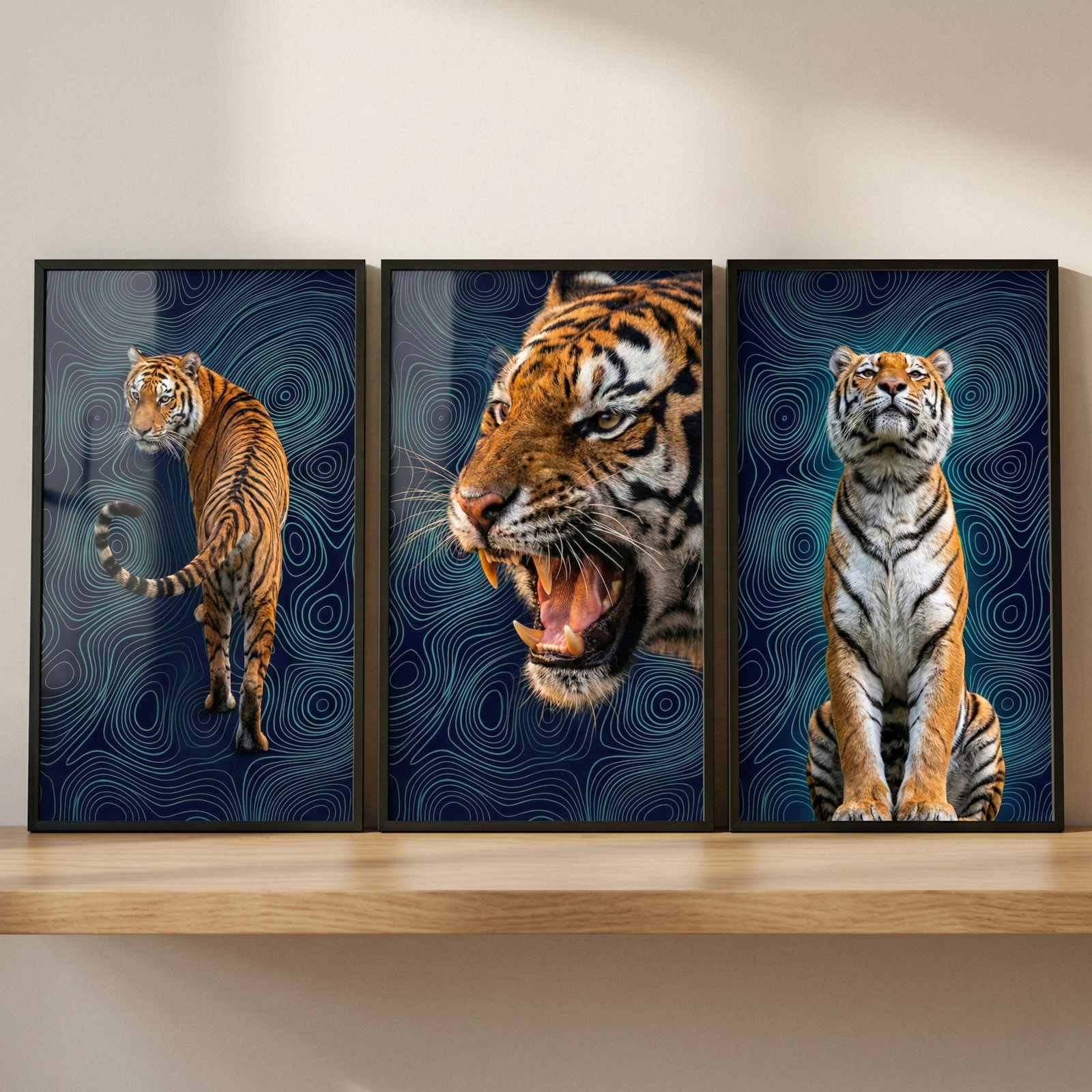 Three framed vertical artworks of tigers are arranged side-by-side above a wooden shelf against a neutral wall. Each piece has a dark blue background with complex, lighter blue swirling line patterns reminiscent of topographical maps. The leftmost frame shows a tiger from the back, looking over its shoulder. The center frame is a close-up of a tiger's face as it roars with an open mouth. The rightmost frame depicts a tiger sitting in an upright, attentive pose while looking upward.
