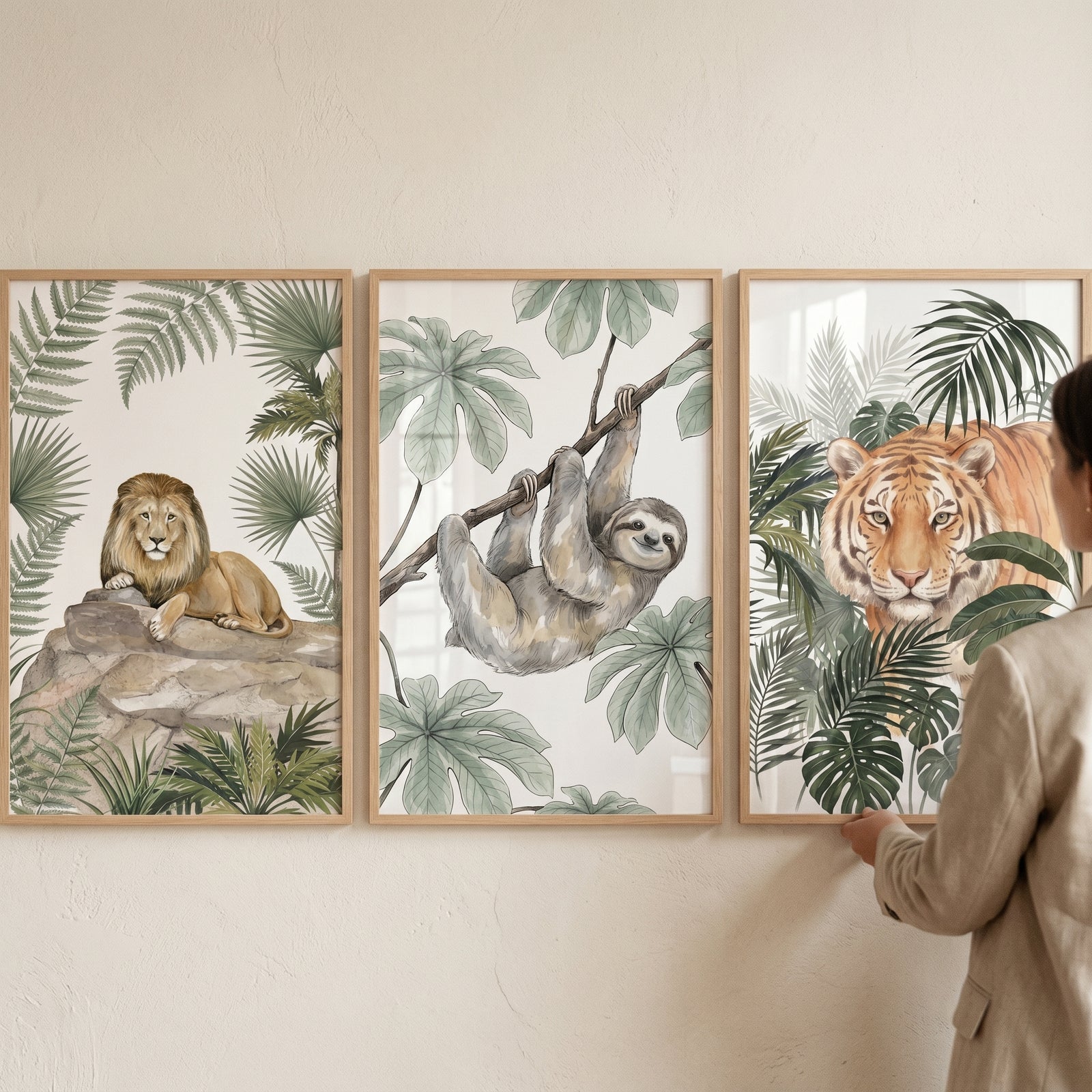 Tropical jungle animals wall art set of 3 including watercolor prints of a lion, a sloth, and a tiger in frames.