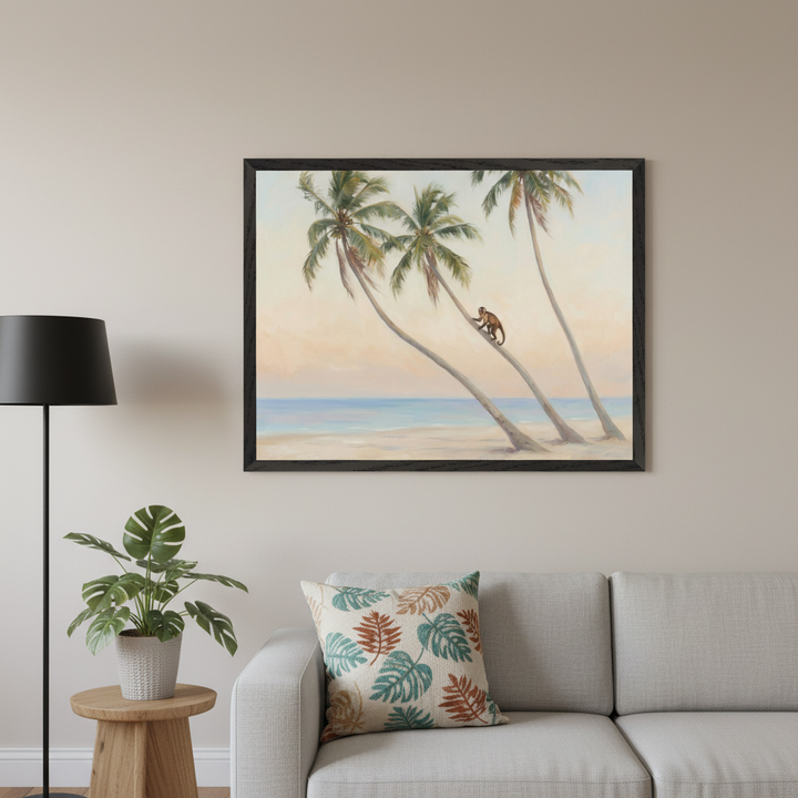 Modern living room with a gray sectional sofa. A large framed painting of a beach with three palm trees and a monkey climbing one, ocean, and a pale sky hangs centered above the sofa. A floor lamp and a plant are to the left.
