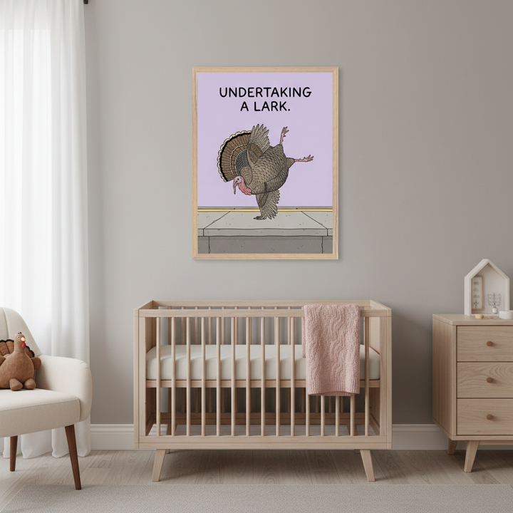 Modern nursery with a light wood crib, matching dresser, and a cream armchair. A framed print featuring a cartoon turkey balancing on one leg on a sidewalk, with "UNDERTAKING A LARK." text, hangs on the gray wall above the crib.