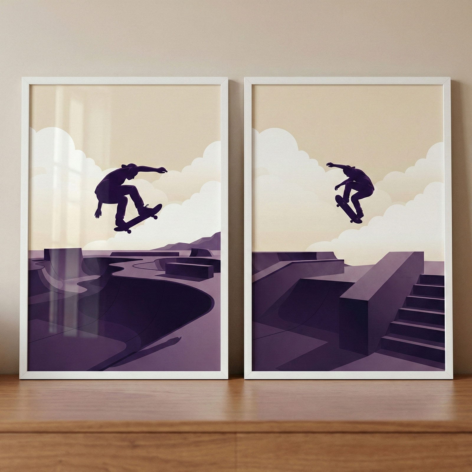 Two minimalist framed illustrations of skateboarders are displayed side-by-side on a wooden surface. Both pieces feature dark purple silhouettes of skateboarders performing mid-air tricks against a warm cream sky with soft, puffy clouds. The left illustration depicts a skateboarder over a purple-toned skatepark with a large curved bowl. The right illustration shows a skateboarder jumping over a purple-toned skatepark with stairs and rectangular ledges. 